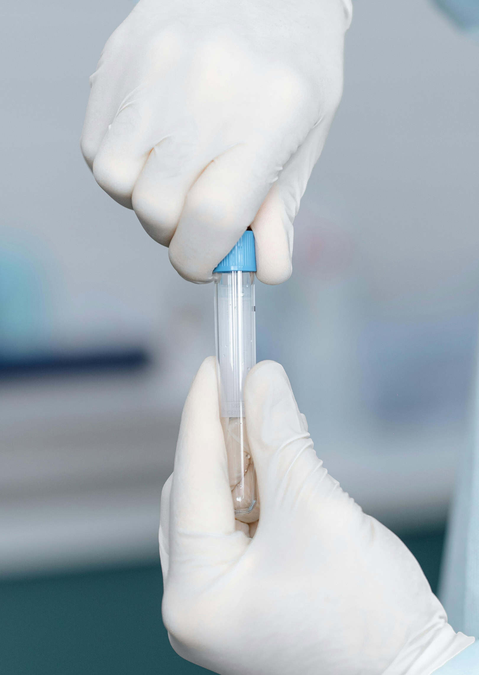 Embryologist holding a labelled sample vial in the fertility laboratory